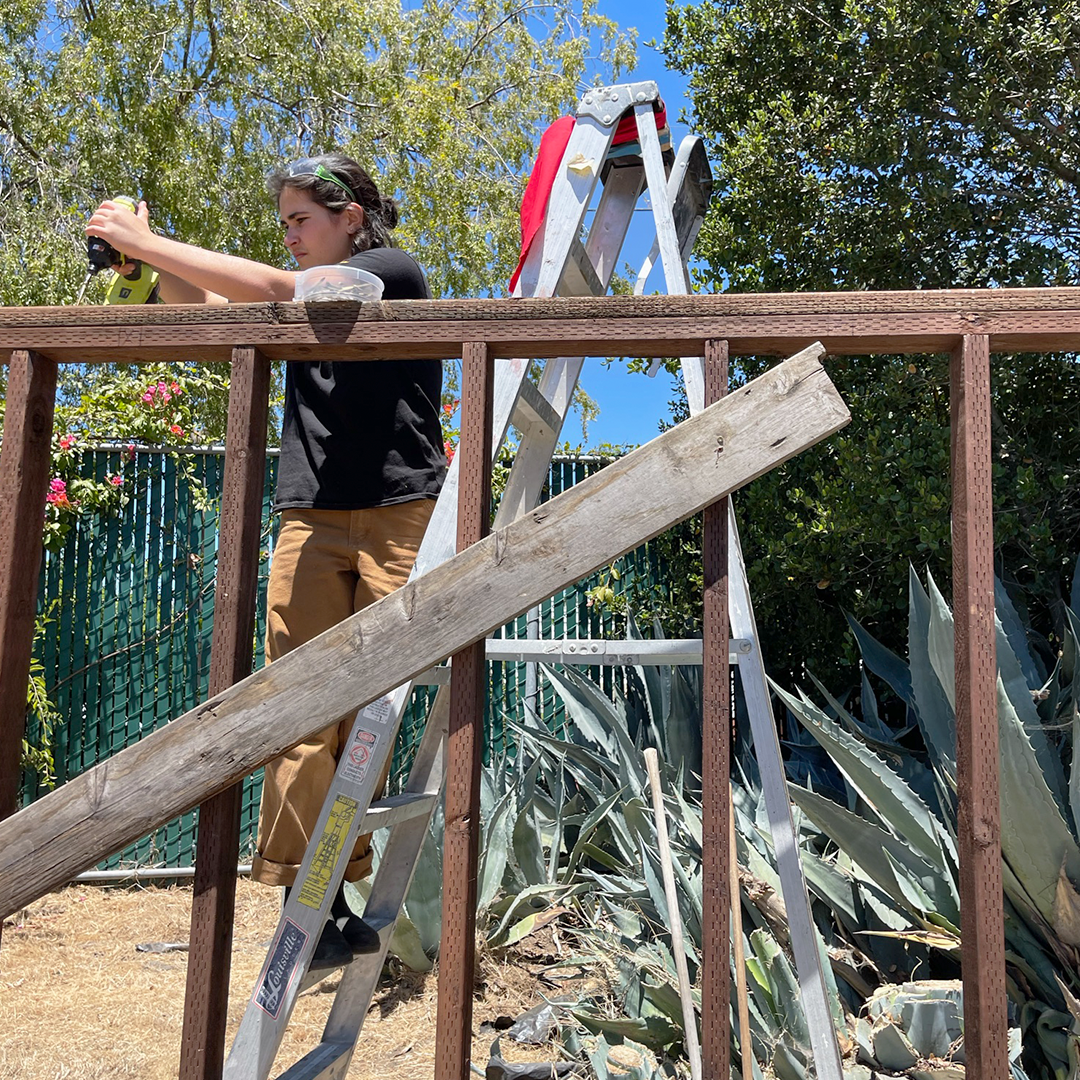 Teen builder works on framing wall