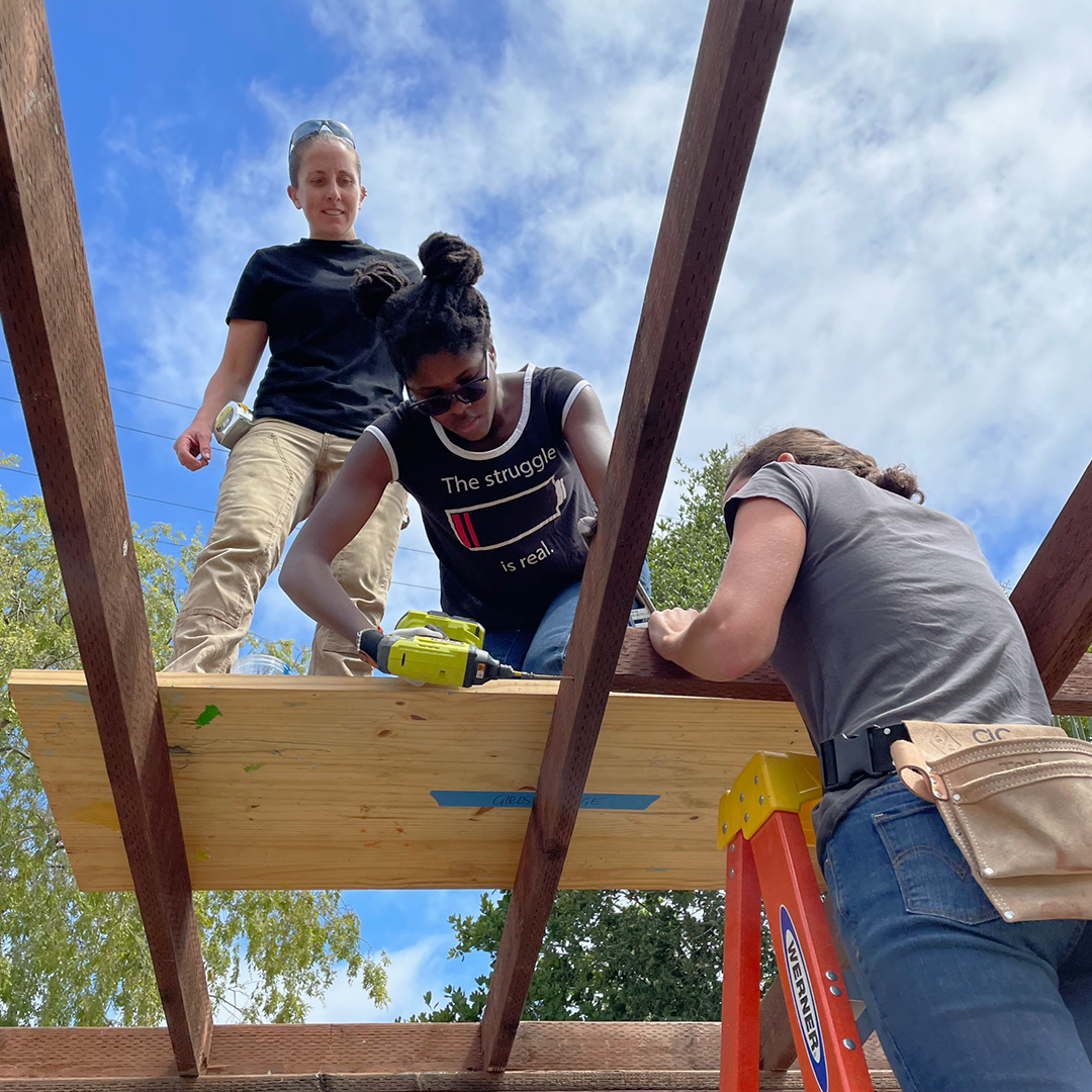 Girls Garage builders build out the roof of greenhouse