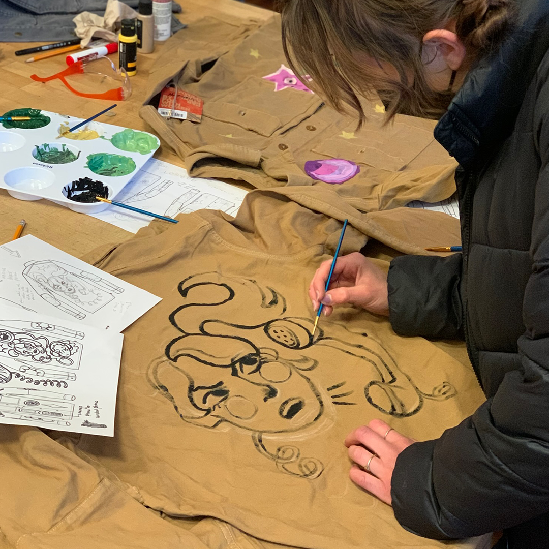 Student painting back of jacket